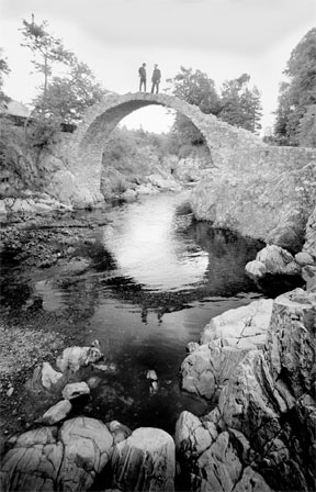 Zwei Männer stehen auf einer alten Steinbrücke